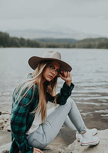 woman sitting on rock near body of water thumbnail