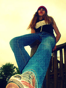 woman in blue shirt sitting on brown wooden fence thumbnail