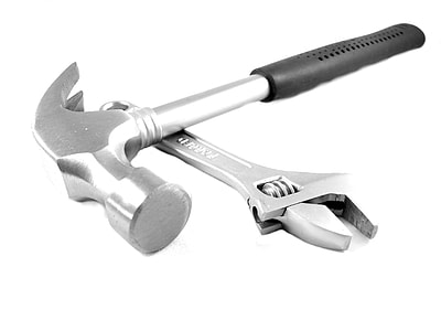 black handle hammer over gray adjustable wrench on white surface thumbnail