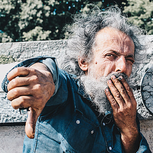 man covering his mouth white doing thumbs down sign thumbnail