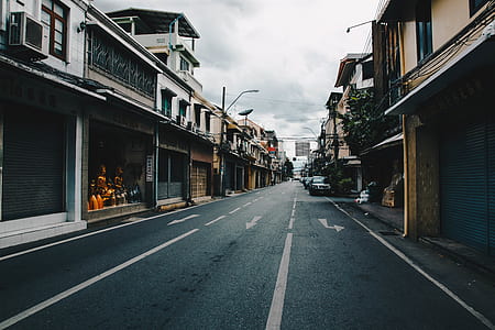 wide road with buildings and vehicle parks thumbnail