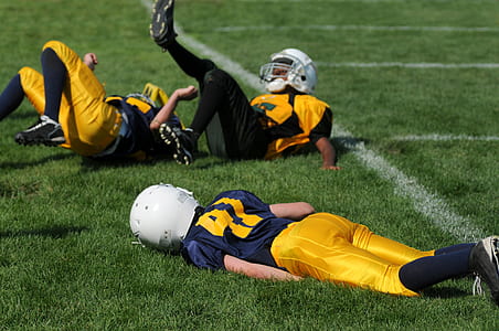 football players laying on ground thumbnail