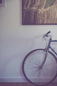 minimalist photography of road bike under black framed painting thumbnail