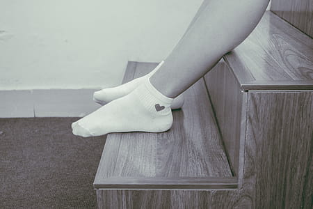 Person Wearing Pair of Foot Socks Sitting on Staircase thumbnail