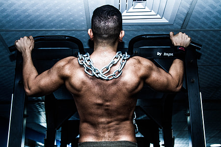 man pull his self on black pull up bar with chains on his shoulder thumbnail