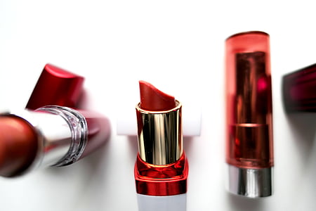 three red lipsticks on white surface close-up photography thumbnail
