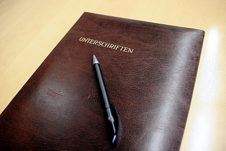 black and silver retractable pen on brown leather book thumbnail