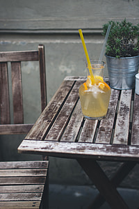 Orange lemonade at a wooden desk outside thumbnail