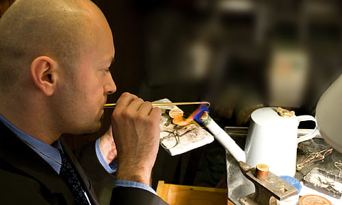 man holding stick in front of teapot thumbnail