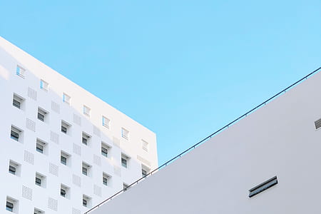 worm's-eye view photography of white concrete building under clear sky thumbnail