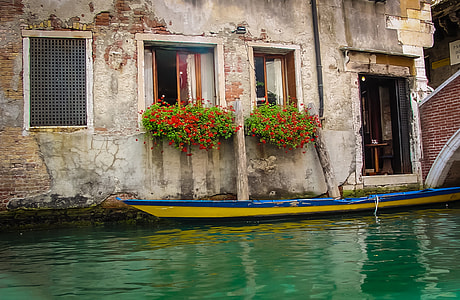 blue and yellow canoe near gray concrete building thumbnail
