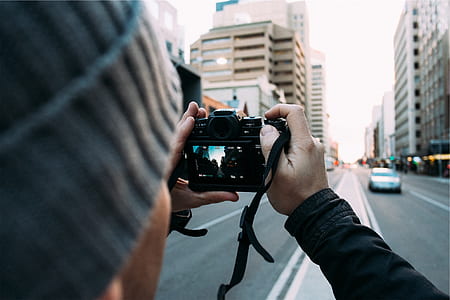 man taking photo of city streets thumbnail