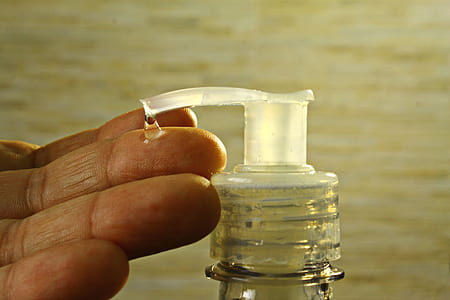 person touching clear liquid drop from pump bottle thumbnail