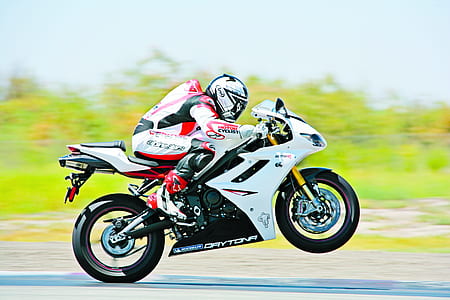 panning photography of person riding white sport bike thumbnail