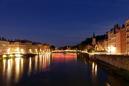 high rise building with lights reflect on calm body of water thumbnail