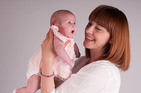 woman in white top carrying baby thumbnail