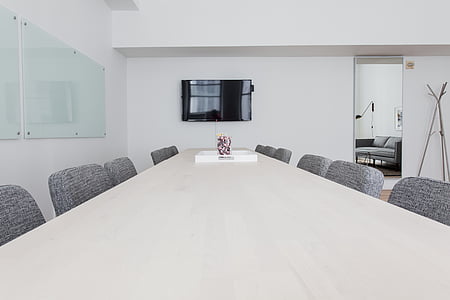 white wooden table surrounded by gray padded chairs thumbnail