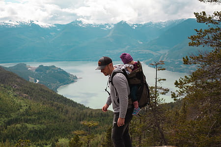 Man Carrying Baby Near Lake thumbnail