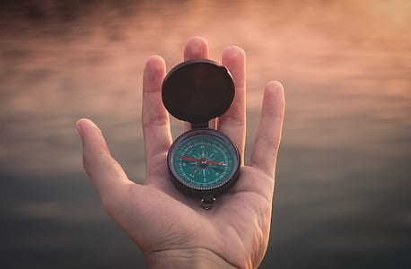 person holding brown compass thumbnail