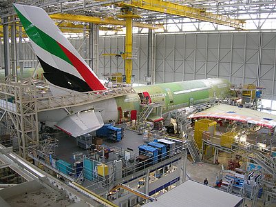 green and white airliner inside building thumbnail