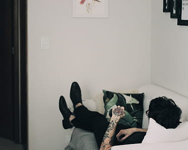 man lying on white sofa thumbnail
