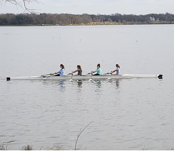four women rowing dragon boat on lake during daytime thumbnail