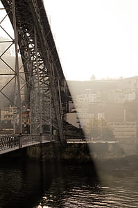 grey metal bridge overlooking concrete buildings at daytime thumbnail
