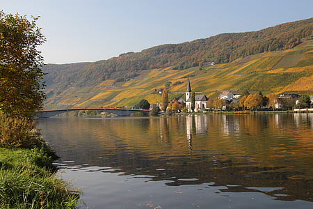 white and brown concrete building beside large calm body of water thumbnail
