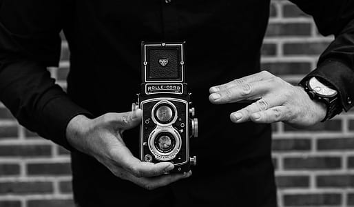 grayscale photo of person holding vintage camera thumbnail