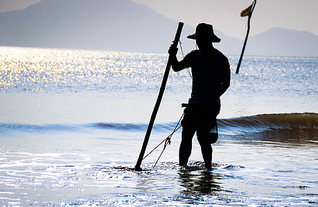 silhouette of a fisherman in body of water thumbnail
