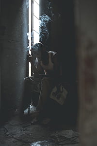 man smoking and sitting inside room thumbnail