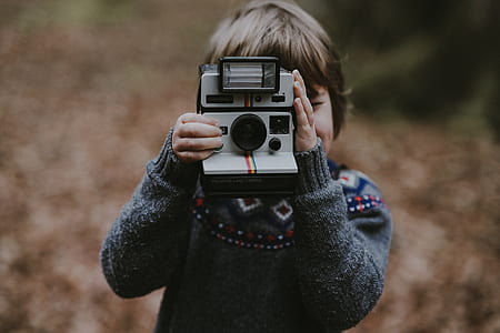boy taking photo using land camera thumbnail