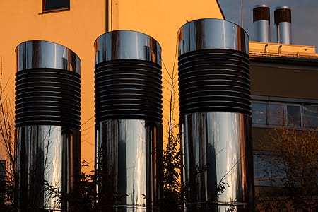 three stainless steel stilos near brown concrete building thumbnail
