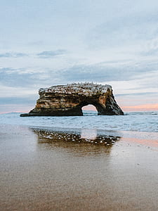 brown and black rock formation by sea thumbnail