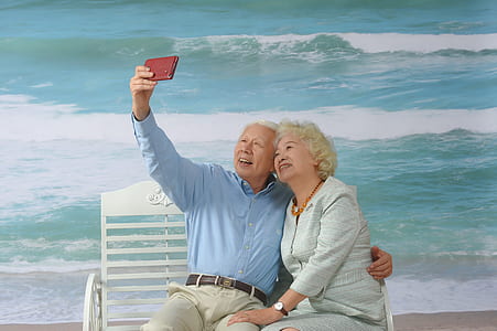 woman and man taking selfie while sitting on bench thumbnail