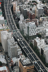 grey concrete road between high rise buildings thumbnail