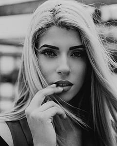 grayscale photo of woman holding her lips thumbnail