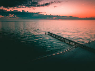 brown wooden dock under white cloudy sky thumbnail