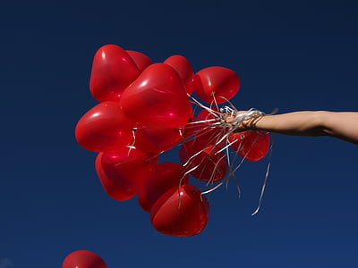 person holding heart balloons thumbnail