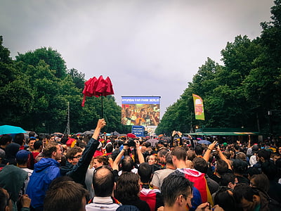 crowded street with man raising his red umbrella thumbnail