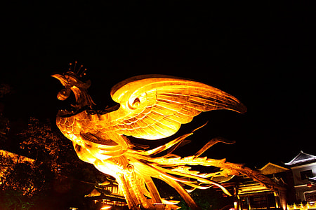 brown wooden eagle sculpture beside house thumbnail
