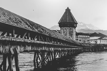 grayscale photography of wooden dock and house thumbnail