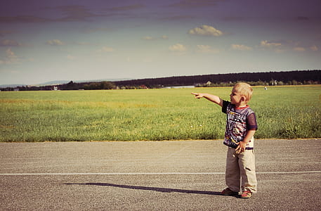 boy standing at pathway raising right hand thumbnail