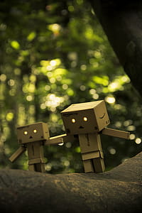 Three Brown Cardboard Box Figures on Brown Surface thumbnail