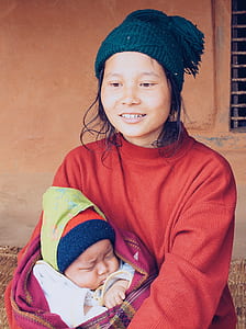 woman carrying baby during daytime thumbnail