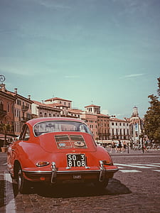 vintage red car parked on roadside during daytime thumbnail