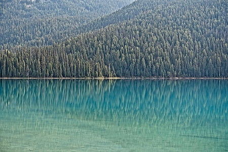 body of water near mountain during daytime thumbnail