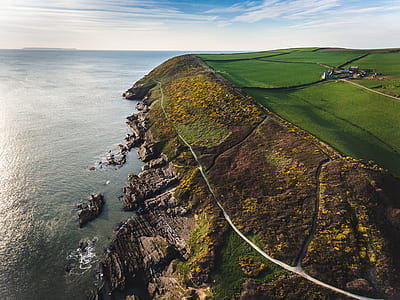 aerial photography of cliff beside ocean during daytime thumbnail