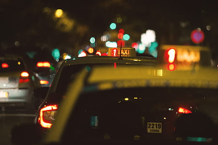 selective focus photo of white Taxi on roadway during nighttime thumbnail