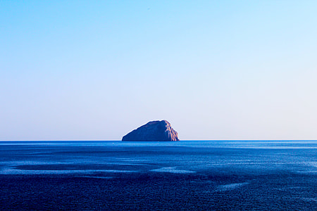 island between on calm body of water thumbnail